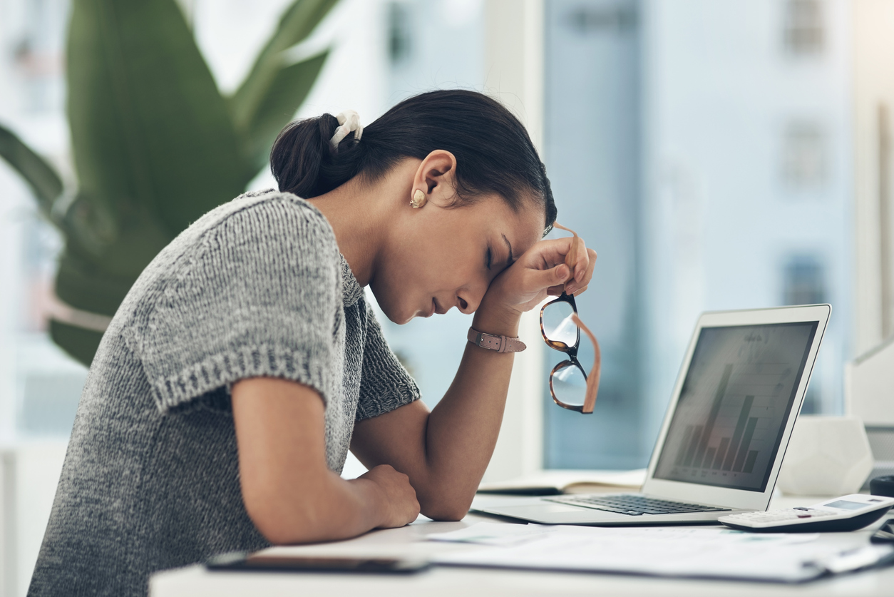 Shot of a young businesswoman looking stressed out while working in an office