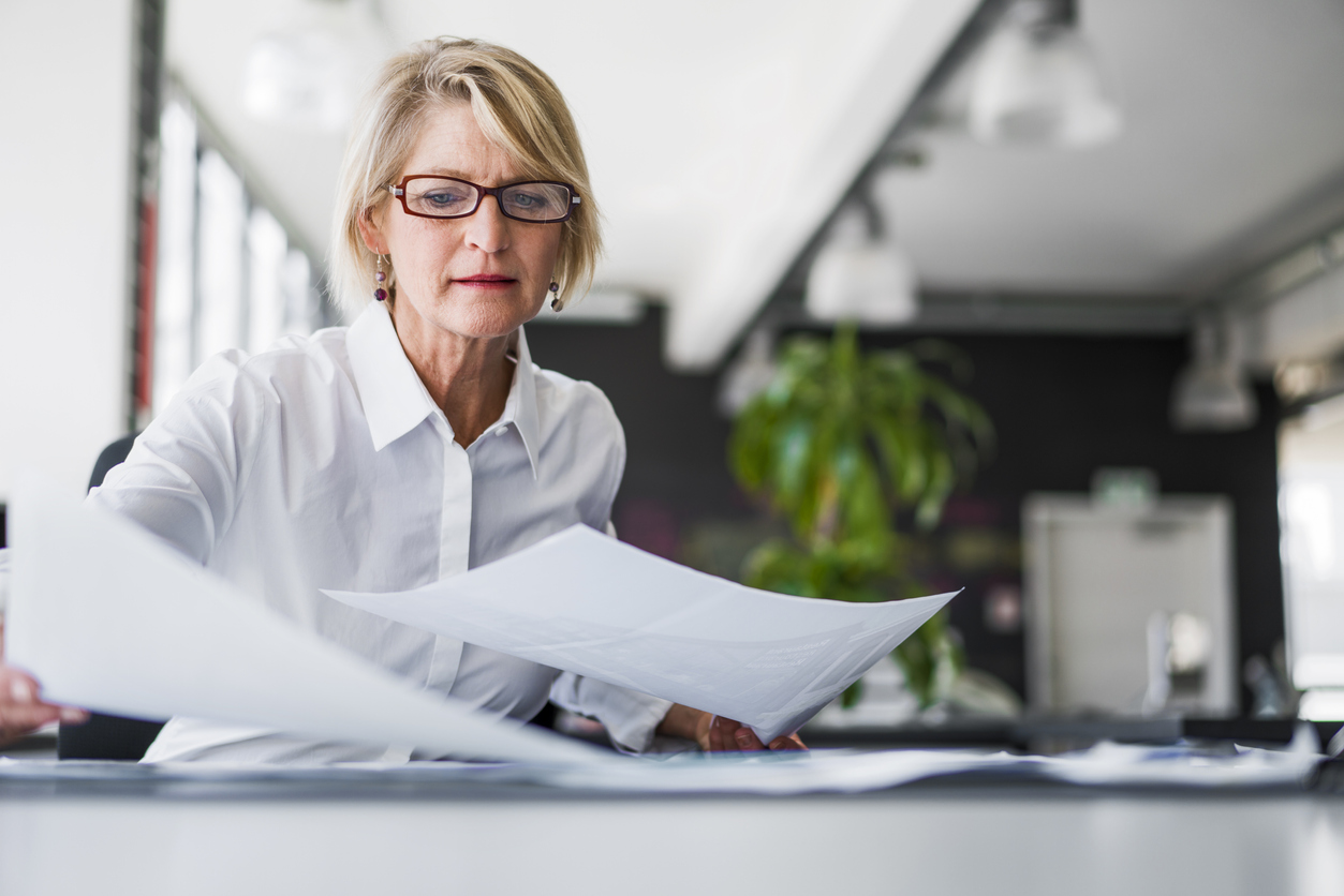 Older corporate women looking at paper